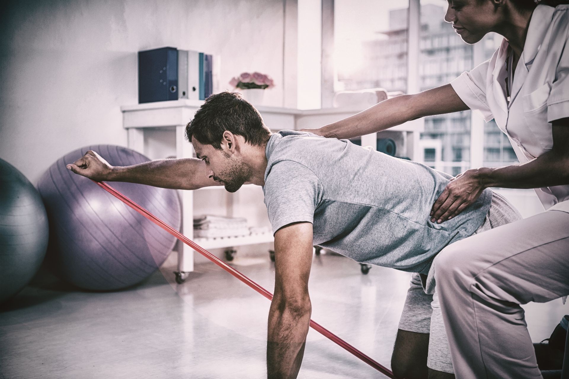 Female physiotherapist assisting a male patient while exercising in the clinic